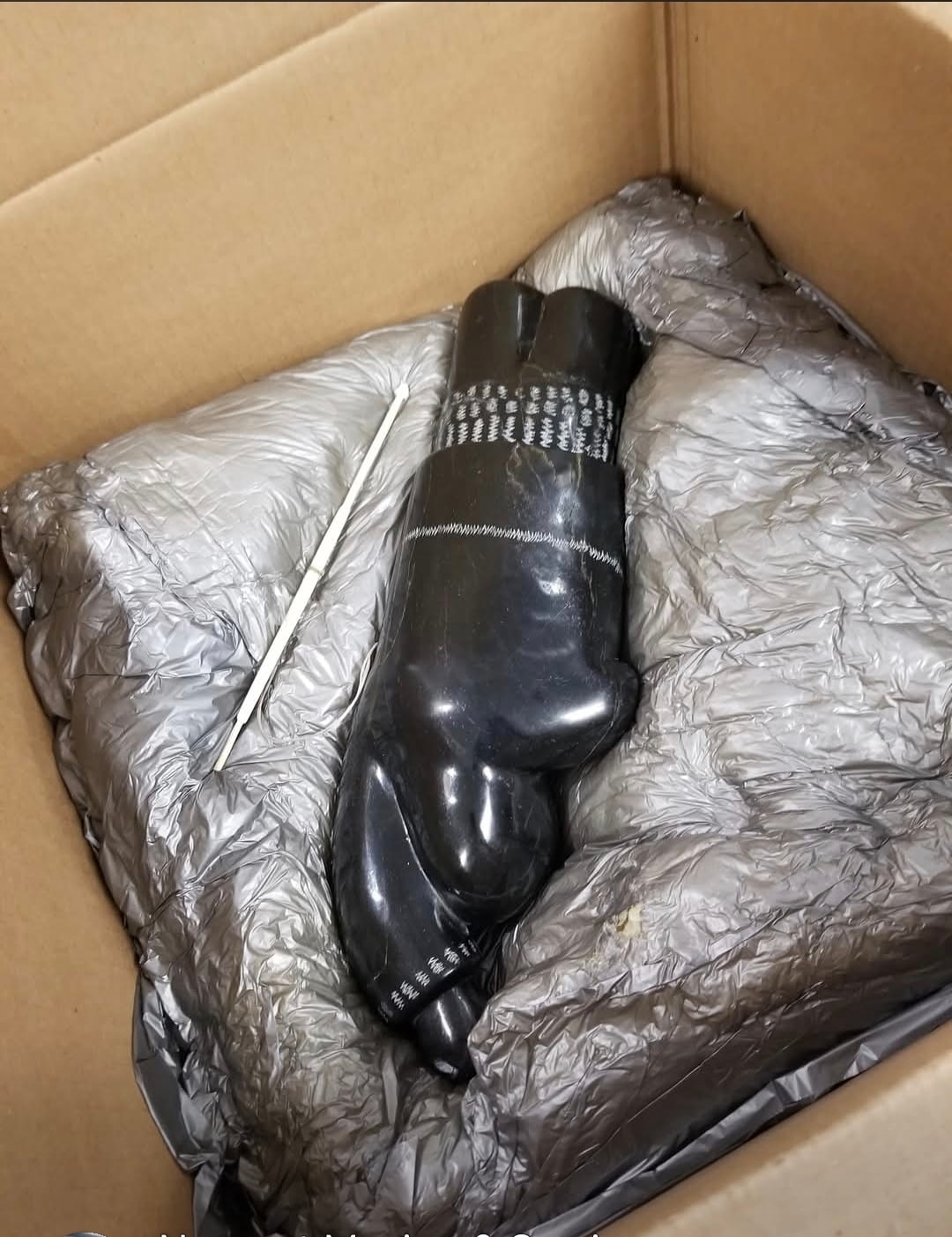 Inuit sculpture wrapped in protective material and secured in a shipping box