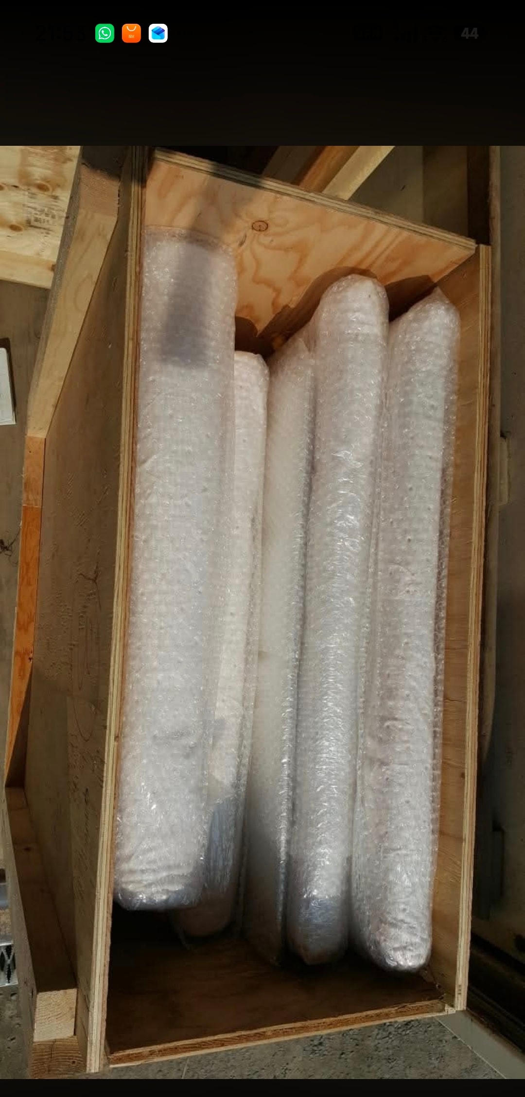 Rolled items bubble-wrapped and packed upright inside a custom wooden crate